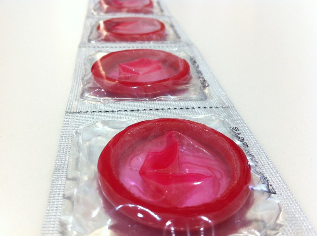 A line of clear-wrapped pink condoms can reduce the risk of STDs; you can check your risk with the STD symptom checker